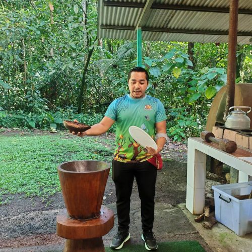 Guide demonstrating cacao grinding with a mortar